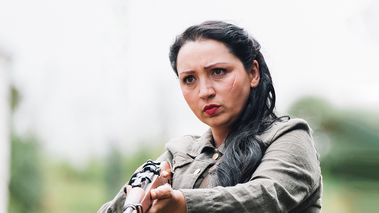 screenshot of a woman holding a rifle